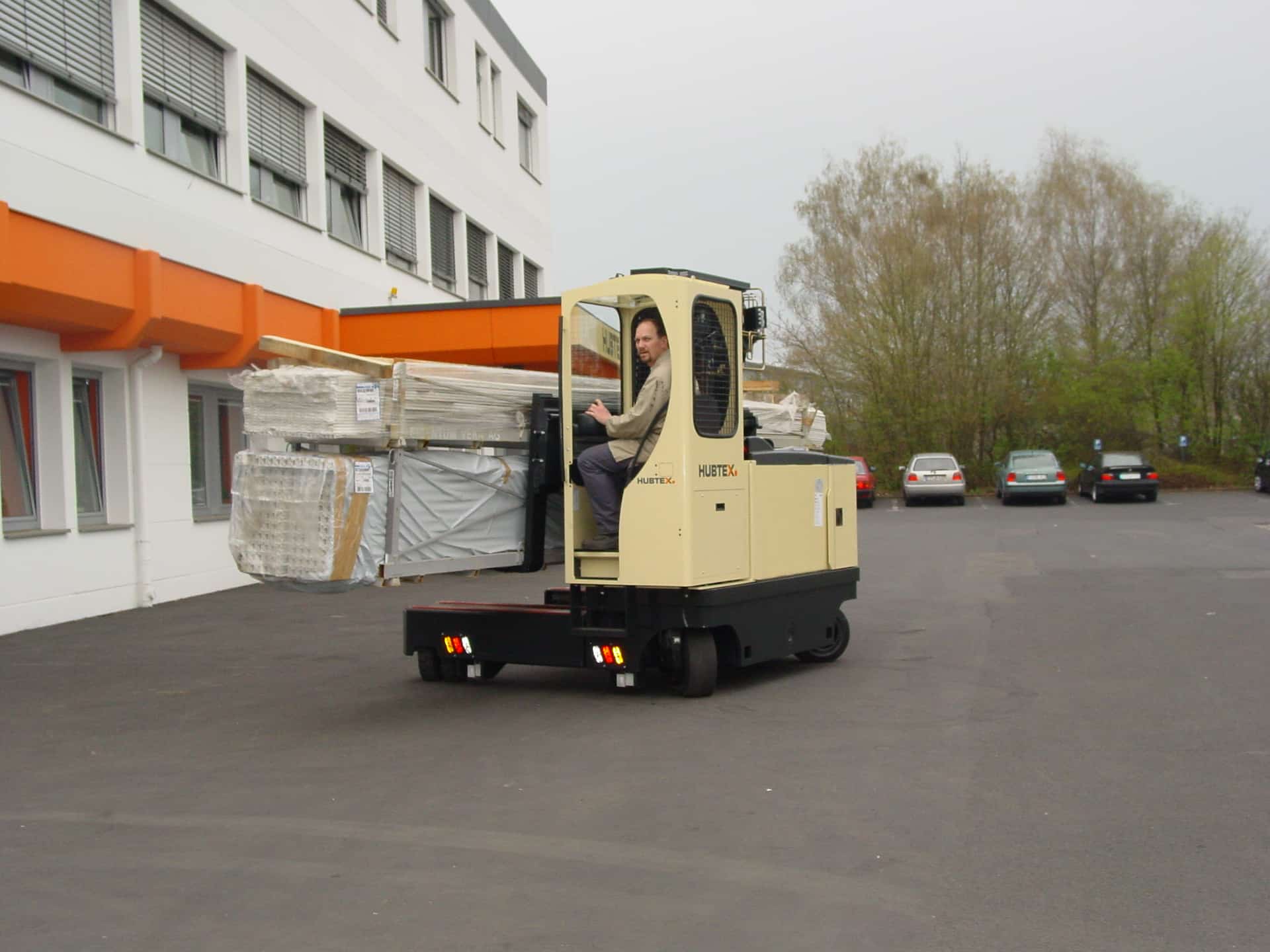 Elektro-Mehrwege-Seitenstapler beim Handling von Holzpaletten