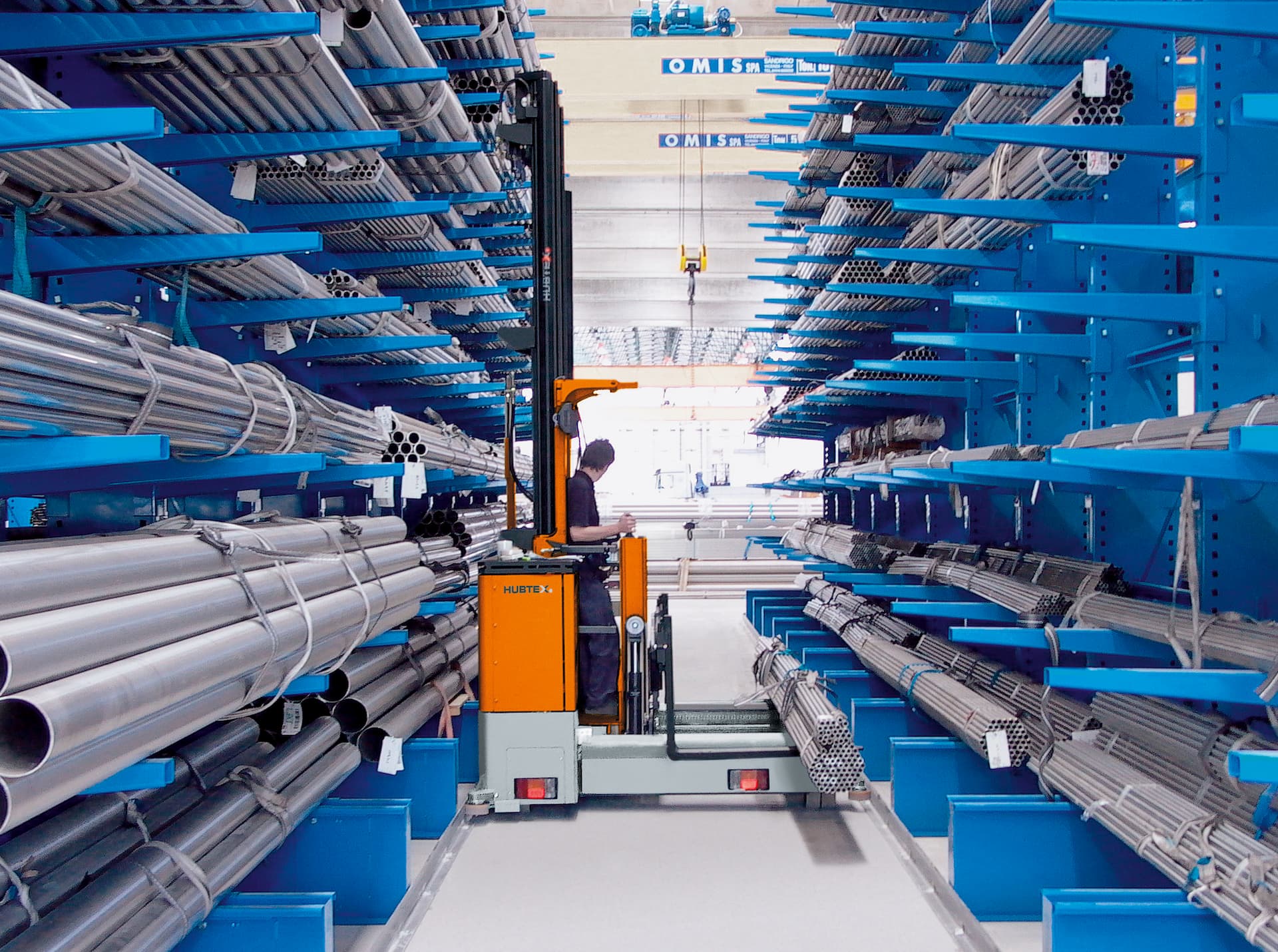 La carretilla elevadora recogepedidos multidireccional de carga lateral MU-OP de HUBTEX durante la manipulación de aluminio