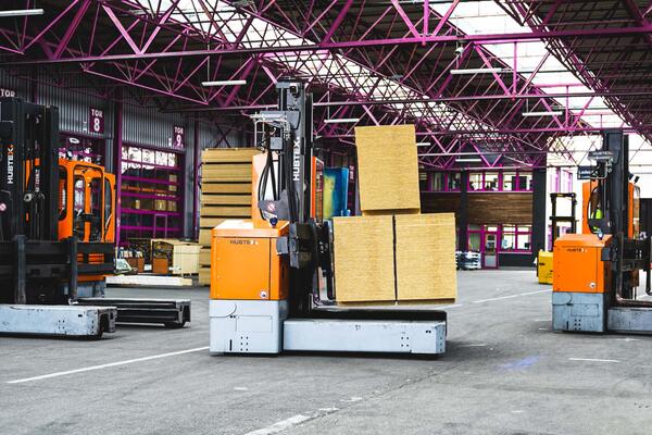 HUBTEX Mehrwe-Seitenstapler transportiert lange Holzpakete