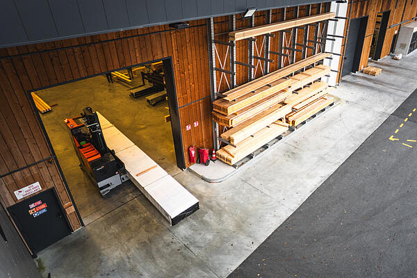Logistique bois : passage sécurisé de charges longues en zone de transition intérieur-extérieur
