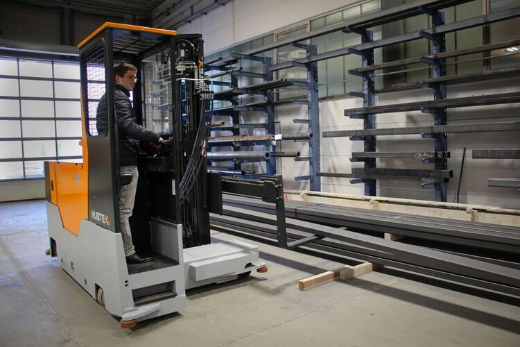 La carretilla elevadora multidireccional de carga lateral HUBTEX Easy en acción en una nave industrial