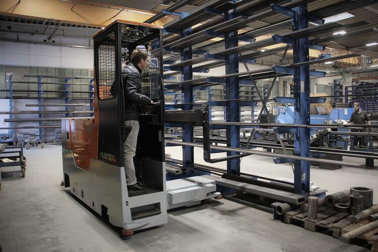 La cabina para ir de pie de la carretilla elevadora multidireccional de carga lateral HUBTEX Easy en acción