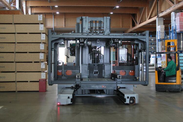 Der HUBTEX Elektro-Mehrwege-Seitenstapler mit aufgenommener Plattform der Serie Vacumax