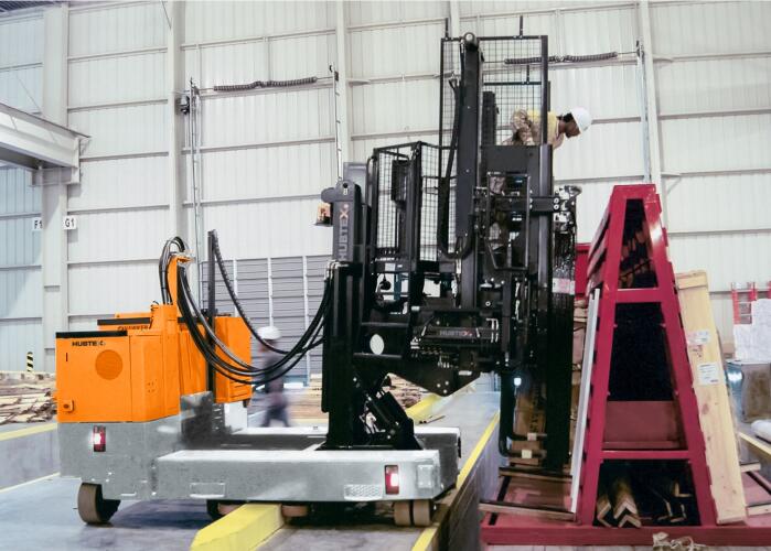 HUBTEX Mehrwege Seitenstapler bei der Lastaufnahme von Glas mit Plattform