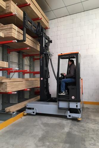 The HUBTEX MaxX multidirectional sideloader lifting a timber pack