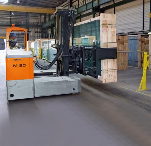 der HUBTEX MQ 80 Mehrwege-Seitenstapler beim Handling von Glaskisten