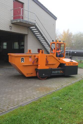 A skip transporter in use outdoors.