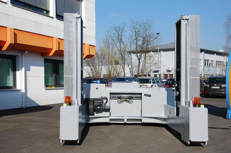 Der Trommeltransporter nimmt die Trommel mithilfe von Pinolen auf.