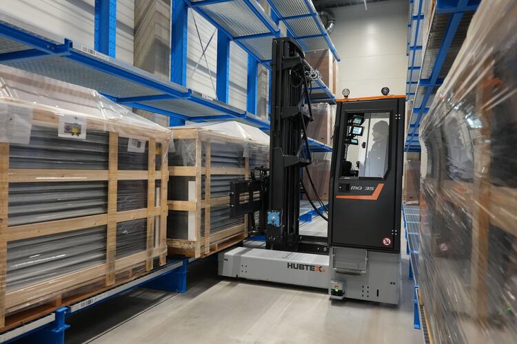 Hubtex Mehrwege- Seitenstapler Phoenix  lagert Ware im Schmalgang aus