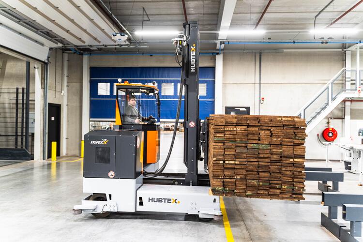 Mehrwege Seitenstapler transportiert langes Holz