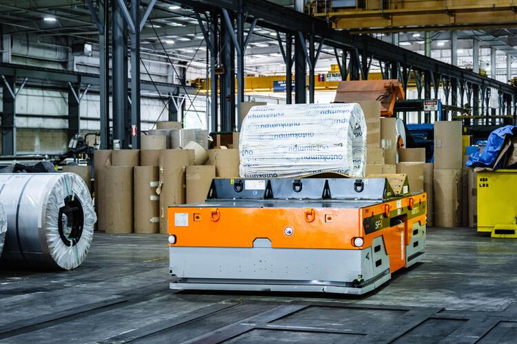 Hubtex SFX 40 heavy-duty platform transports a coil in a warehouse
