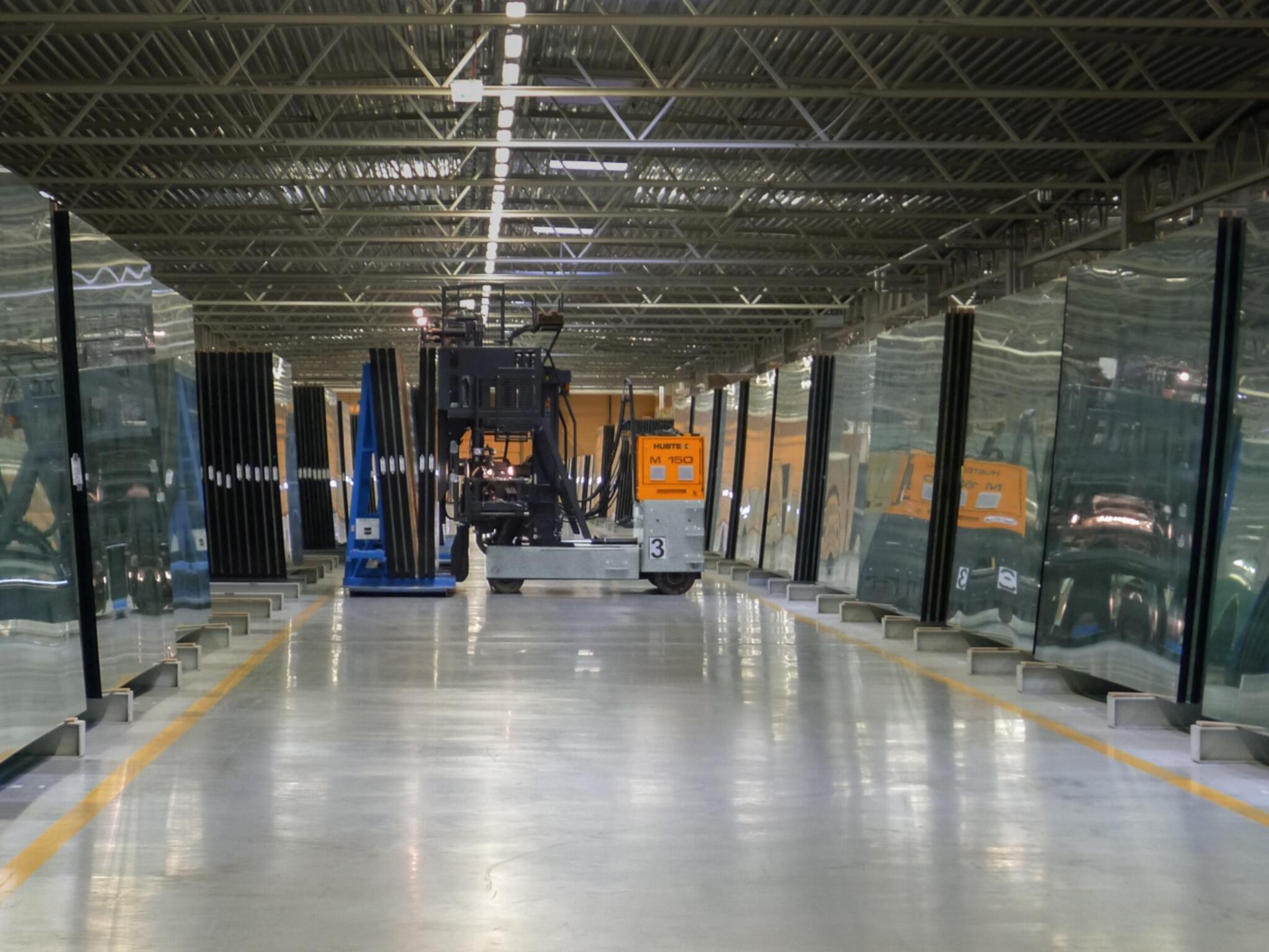 der HUBTEX M150 mit Glasgestell bei der Lastaufnahme