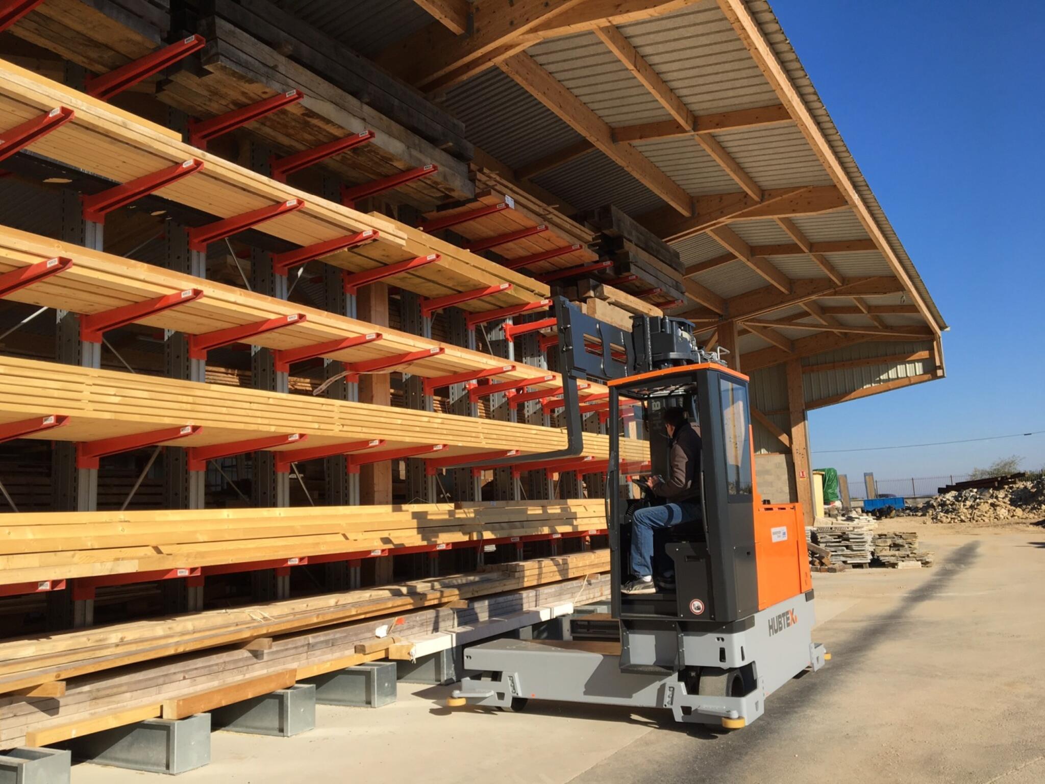 der HUBTEX Mehrwege-Seitenstapler MaxX beim Einsatz bei der Lastaufnahme von Langgut