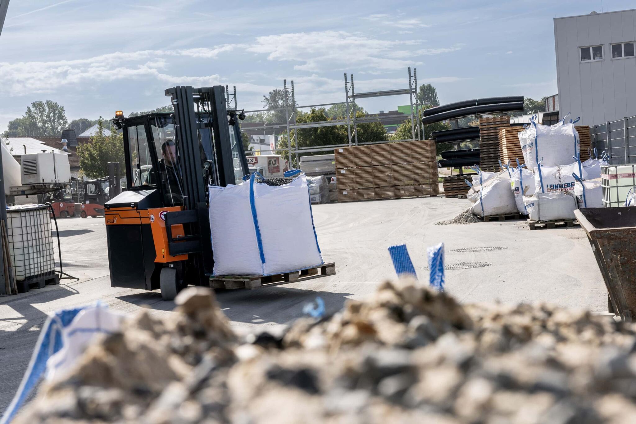 Le chariot élévateur à contrepoids Flux transporte une palette de matériaux de construction