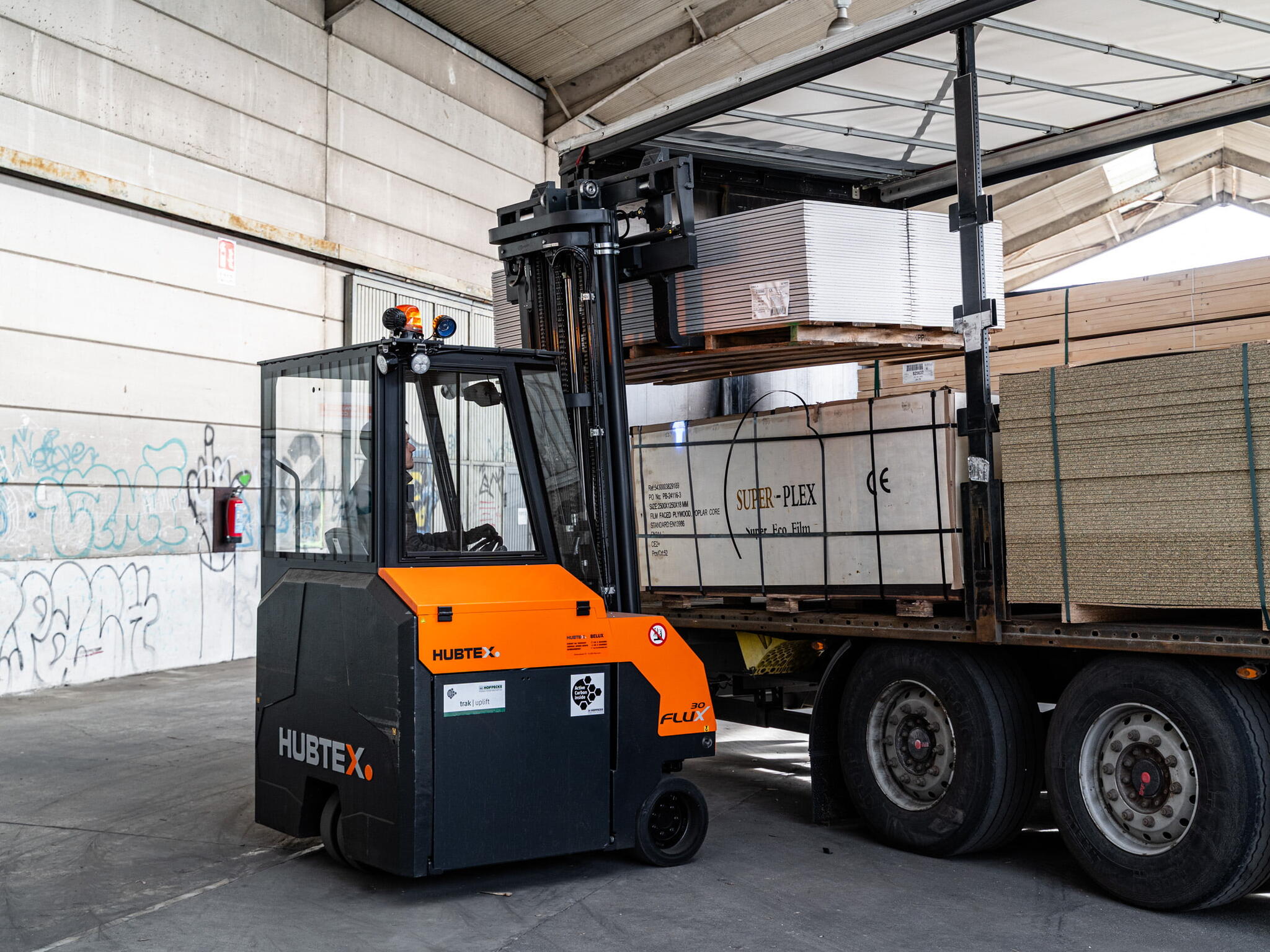 HUBTEX Mehrwege-Gegengewichtsstapler FLUX entlädt einen LKW