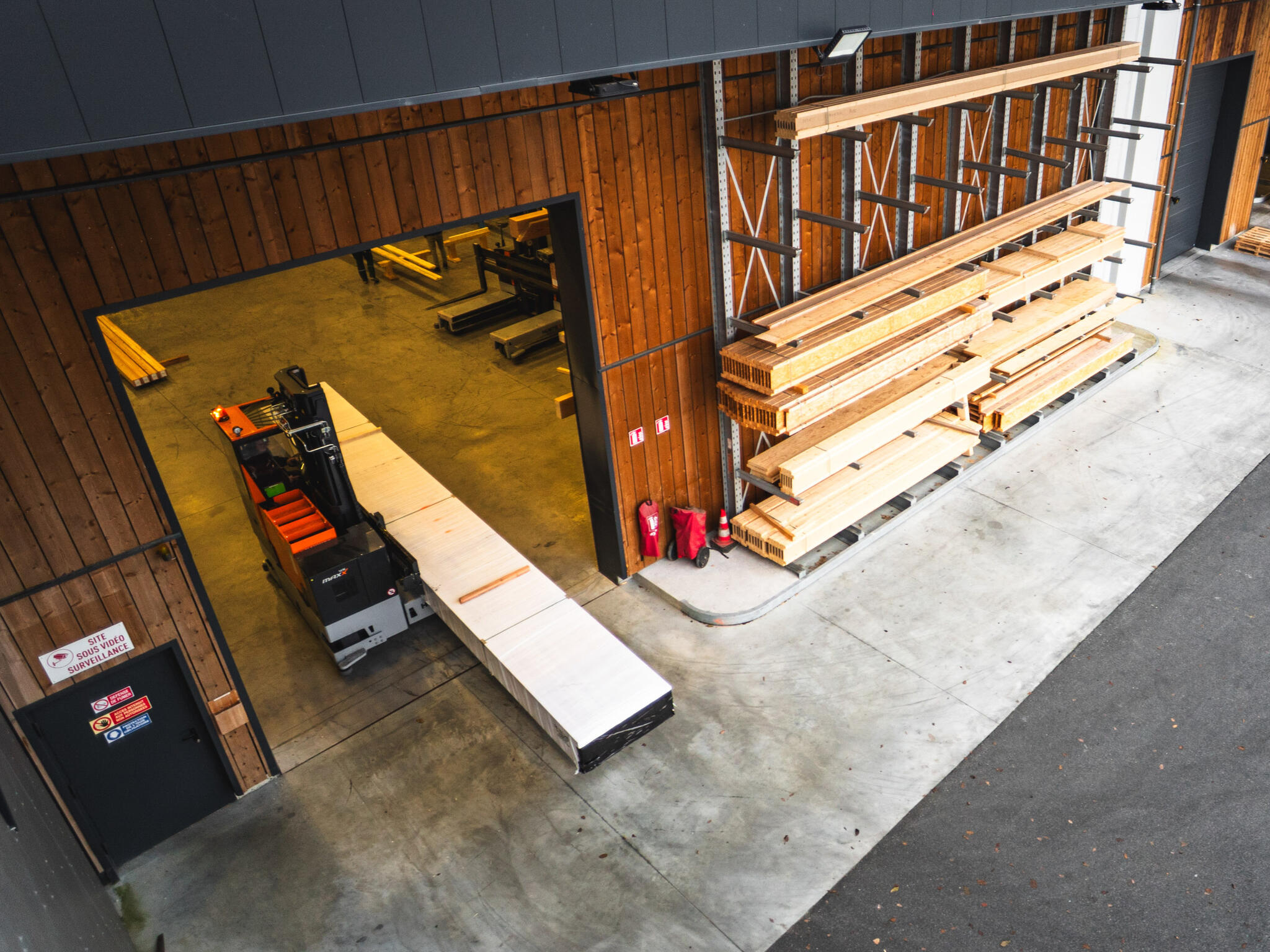 Logistique bois : passage sécurisé de charges longues en zone de transition intérieur-extérieur