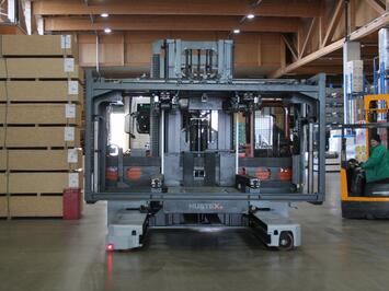 Der HUBTEX Elektro-Mehrwege-Seitenstapler mit aufgenommener Plattform der Serie Vacumax