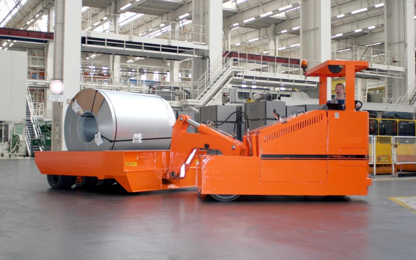 The electric towing tractor with hydraulic gooseneck from HUBTEX during the transport of goods