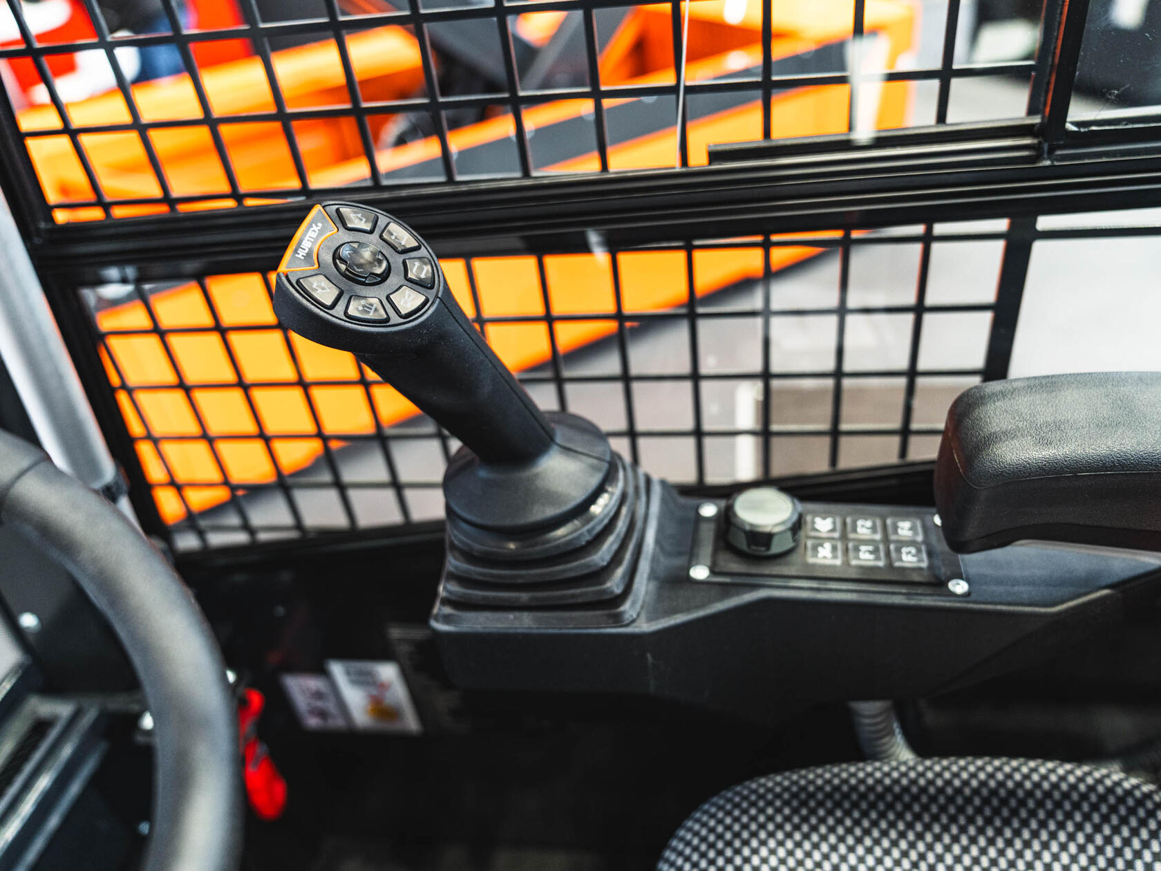 HUBTEX Bedienung mit Joystick mit ergonomischer Daumenablage, Fahrtrichtungswippe und beleuchteten Tasten für präzise Steuerung im Schmalganglager